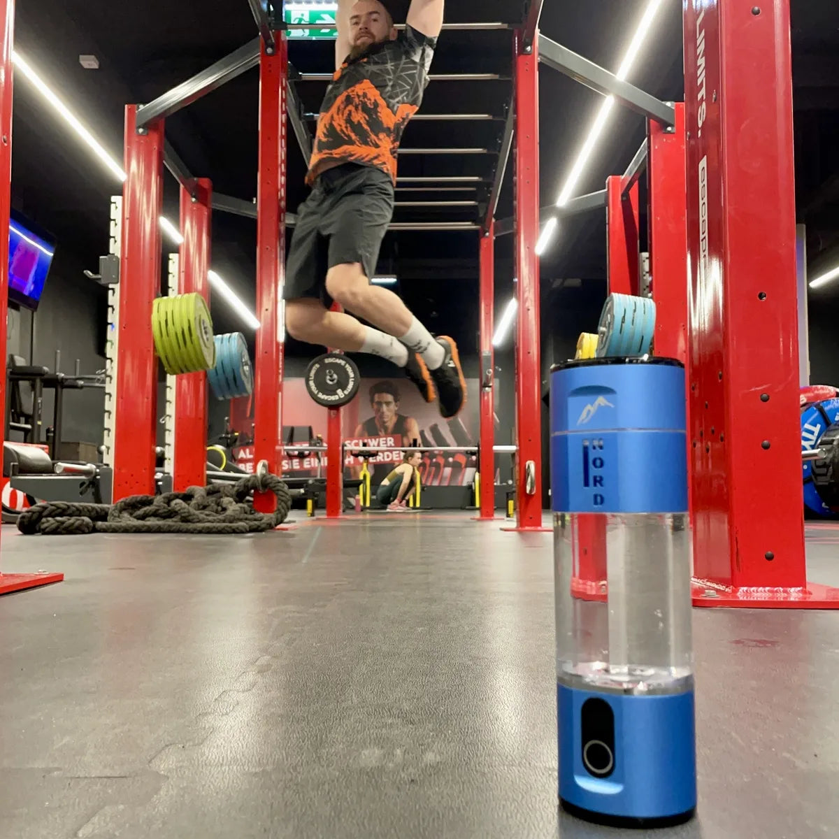 Nord Hydrogen Bottle on the gym floor while Marcus Gail trains on the monkey bars
