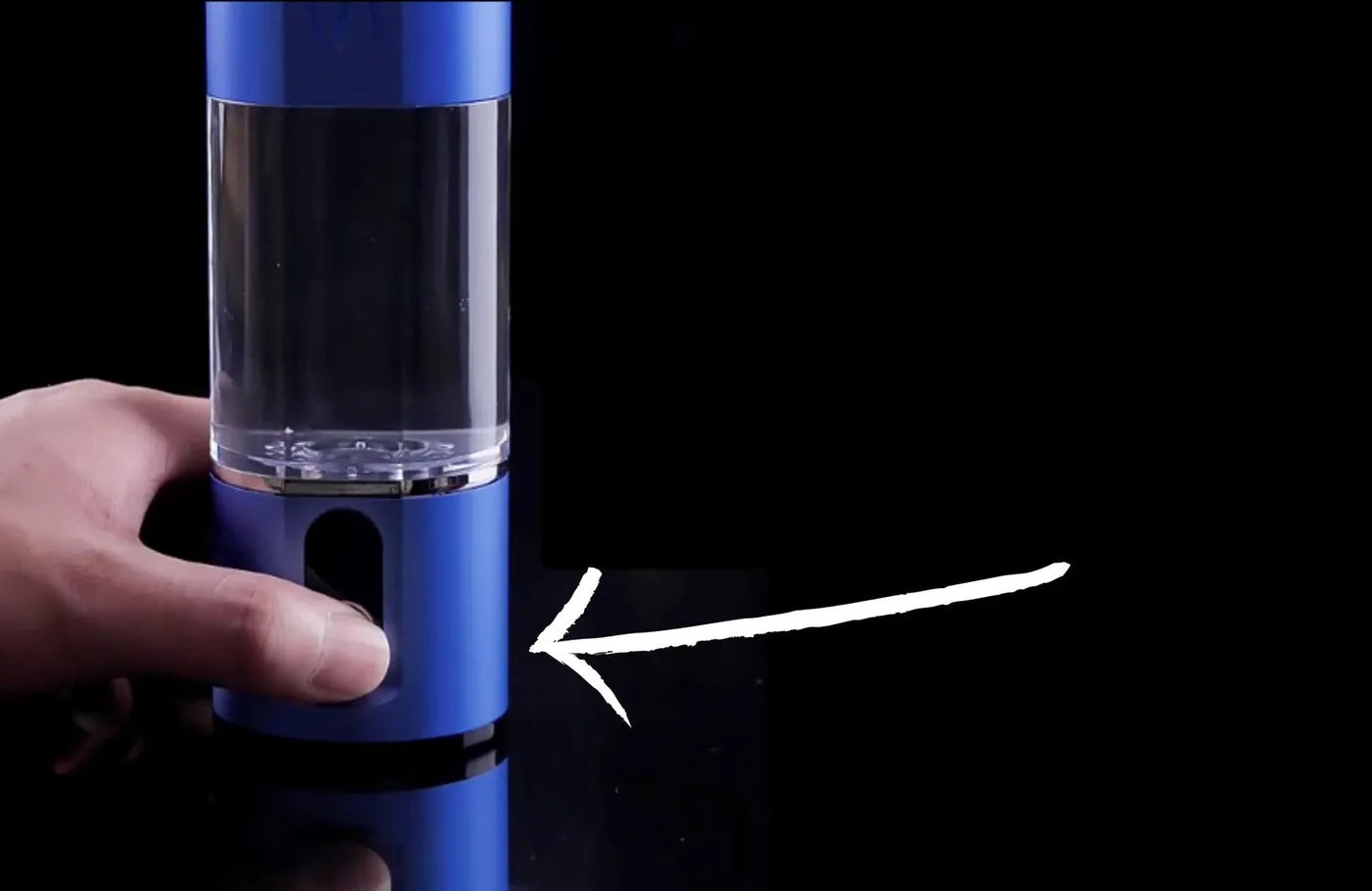 A finger pressing the button on the bottle's base